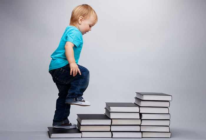 Ребенок идет по ступенькам из книг