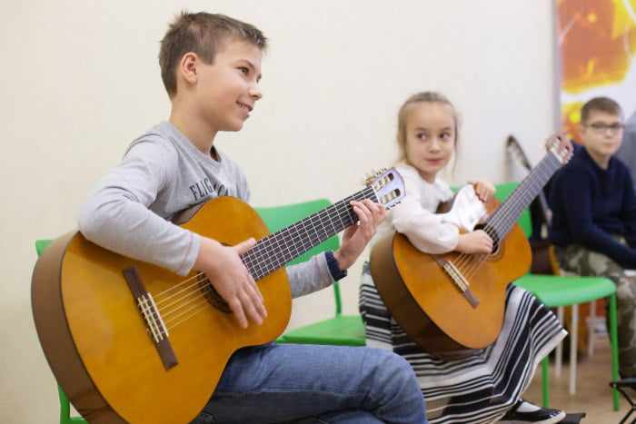 Дети учатся играть на гитаре