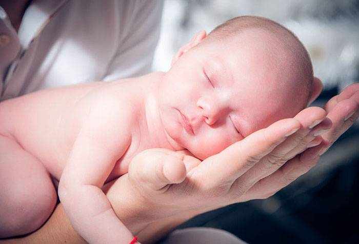 Новорожденный спит на руках