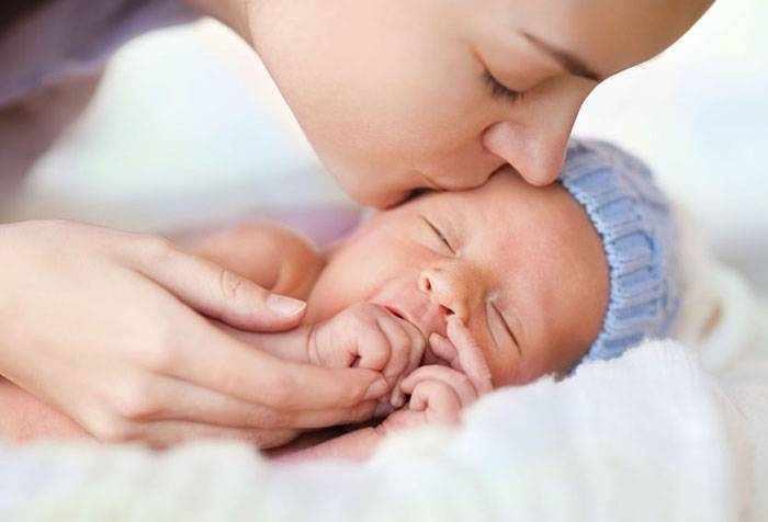 Мама целует новорожденного ребенка