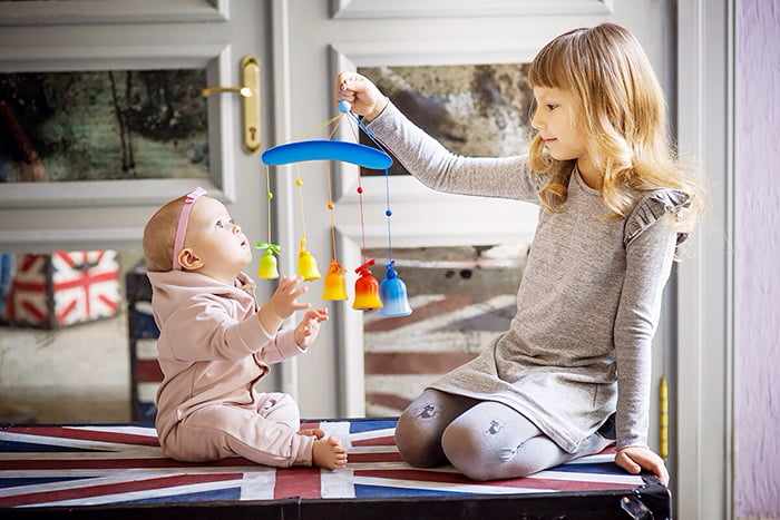 Девочка играет с младшей сестричкой
