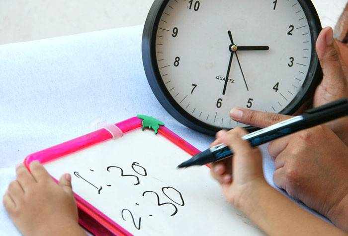 Ребенок учится определять часы и минуты