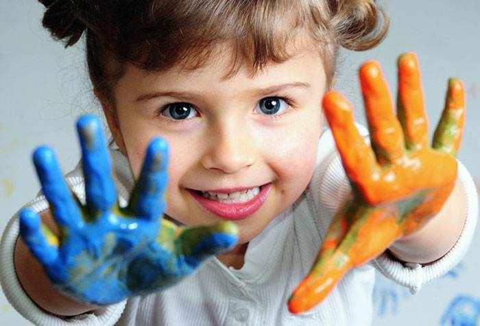 Четырехлетняя девочка играет с красками