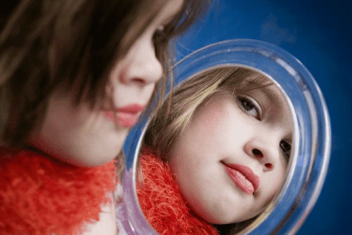 Девочка смотрит в зеркало