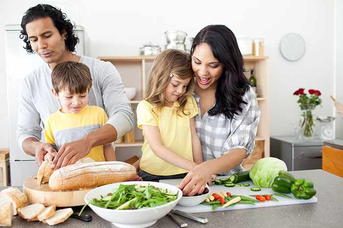 Родители с детьми режут овощи