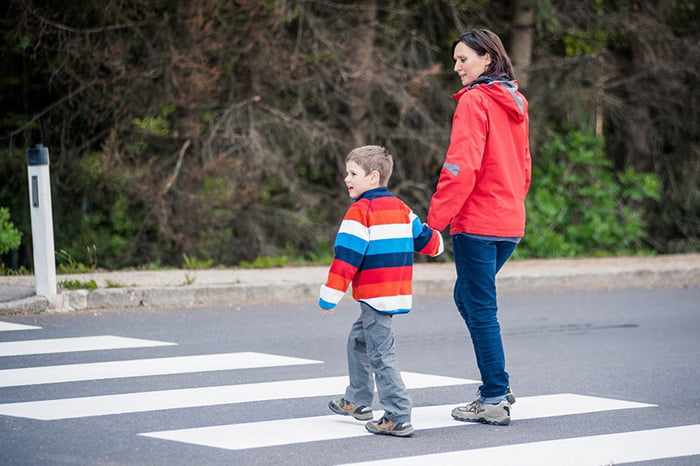 Мама с сыном переходят дорогу