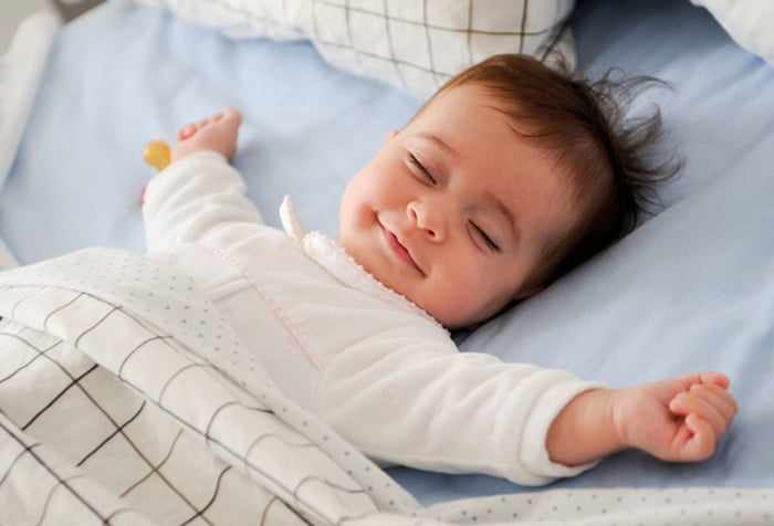 Малыш улыбается во сне