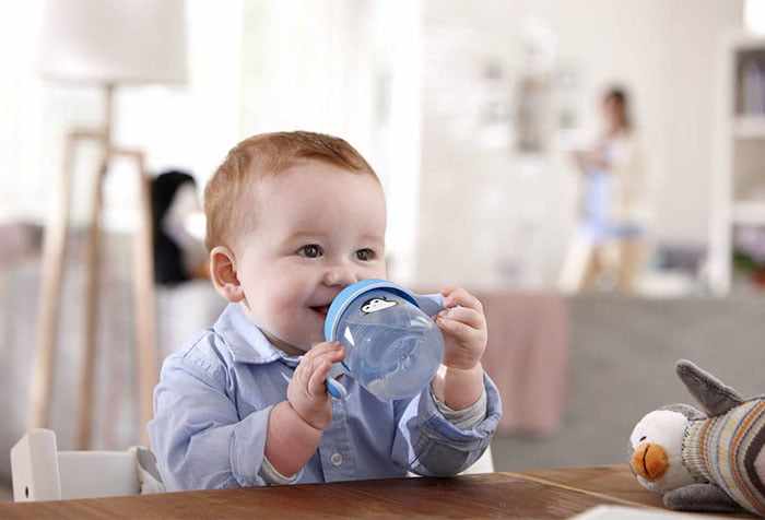 Малыш пьет воду из поильника