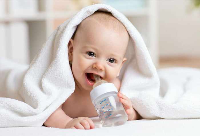 Малыш держит бутылочку с водой