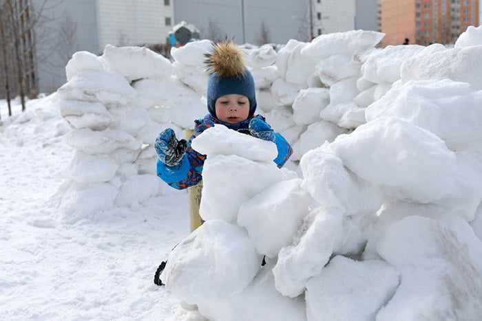 Ребенок строит снежную крепость