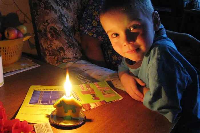 Ребенок за столом со свечой 