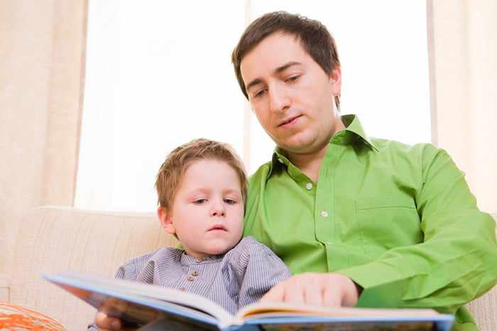Отец читает сыну книгу