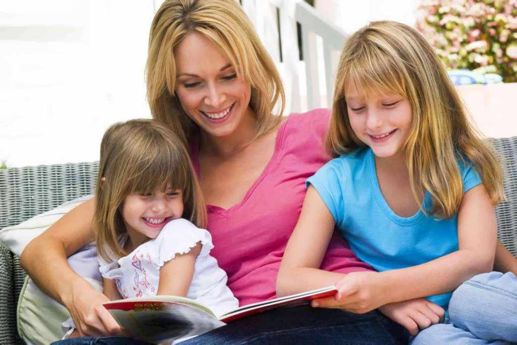 Мама с дочерьми читают книгу