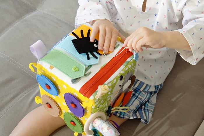 Ребенок играет с развивающим кубиком