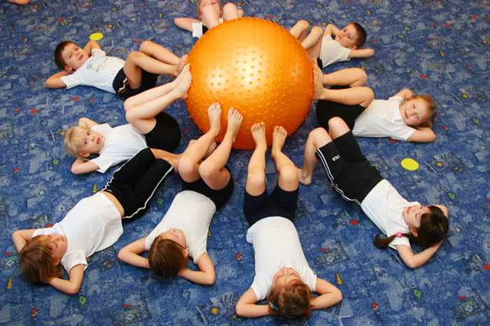 Дети выполняют упражнение с фитболом