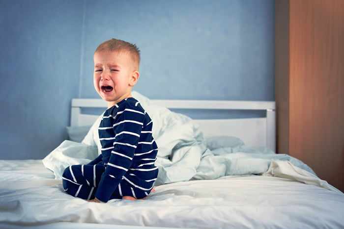 Ребенок плачет в кровати