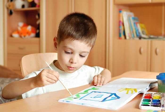 Мальчик рисует красками