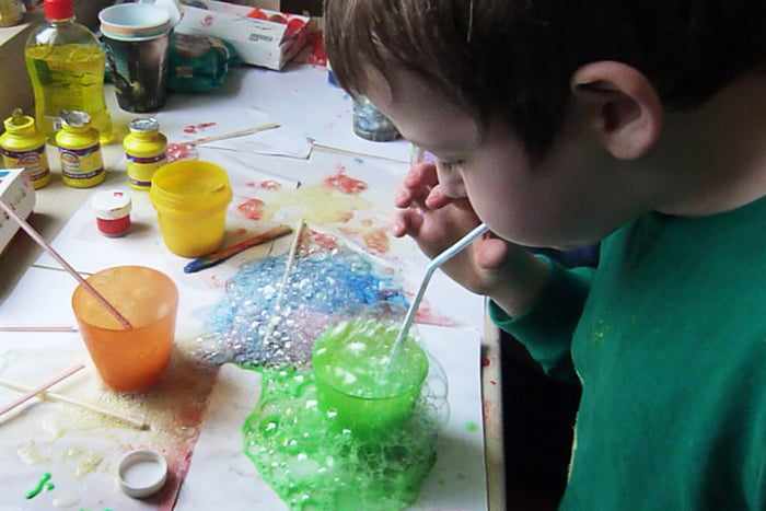 Ребенок рисует мыльными пузырями