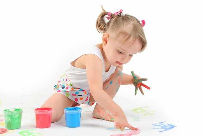 Девочка рисует пальчиковыми красками