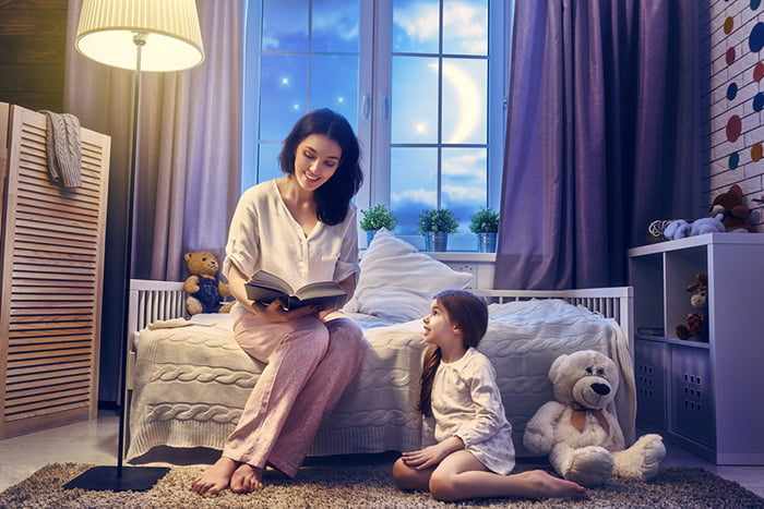 Мама читает дочке сказки на ночь