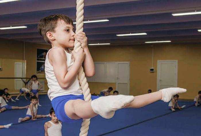 Мальчик занимается спортивной гимнастикой