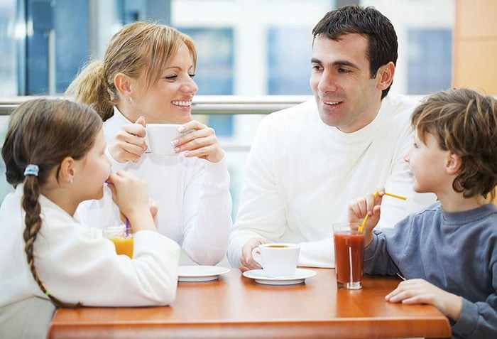 Родители с детьми общаются за столом