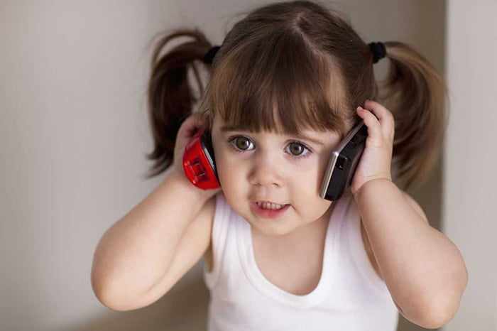 Маленькая девочка с двумя телефонами