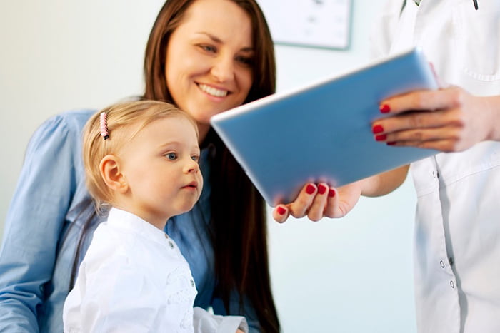 Педиатр показывает центильную таблицу маме и ребенку