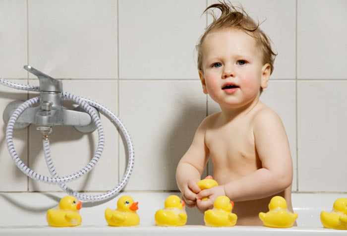 Ребенок в ванне с резиновыми уточками