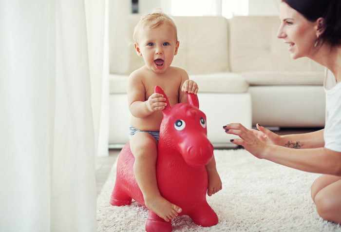 Маленький ребенок на игрушечной лошадке