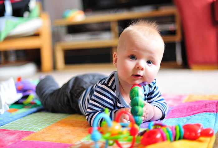 Малыш на ковре с игрушками