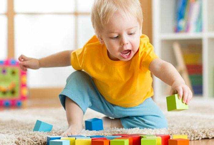 Двухлетний ребенок играет с кубиками