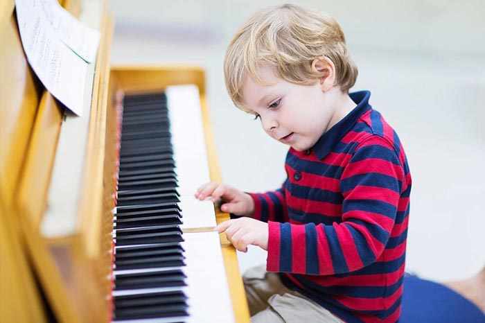Ребенок учится играть на пианино