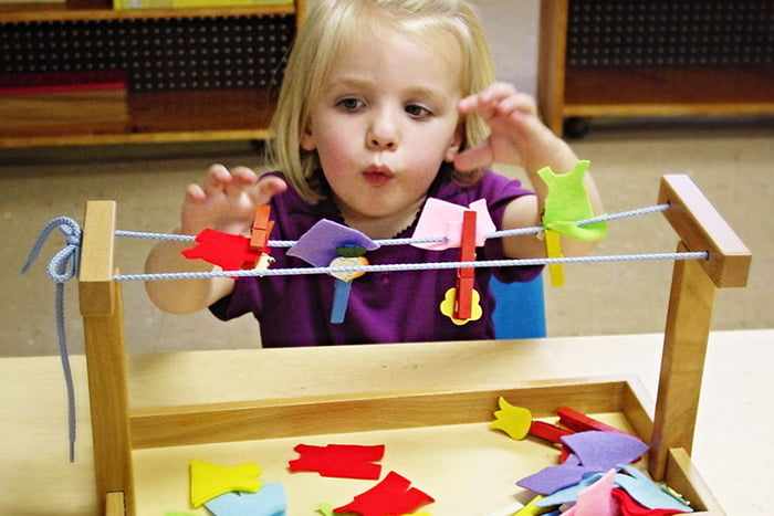 Двухлетняя девочка с развивающей игрушкой по Монтессори