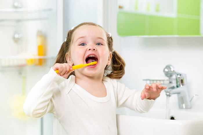 Девочка чистит зубы